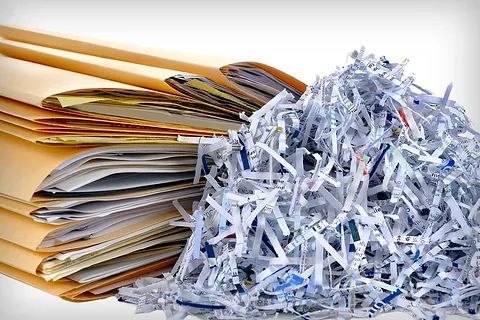 Una pila de papel triturado al lado de una pila de papel triturado.