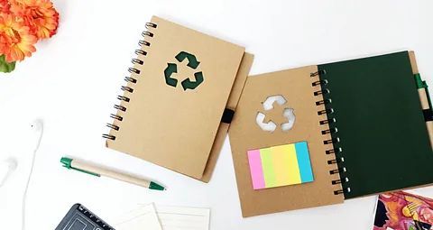 Un par de cuadernos con notas adhesivas y un bolígrafo sobre una mesa.