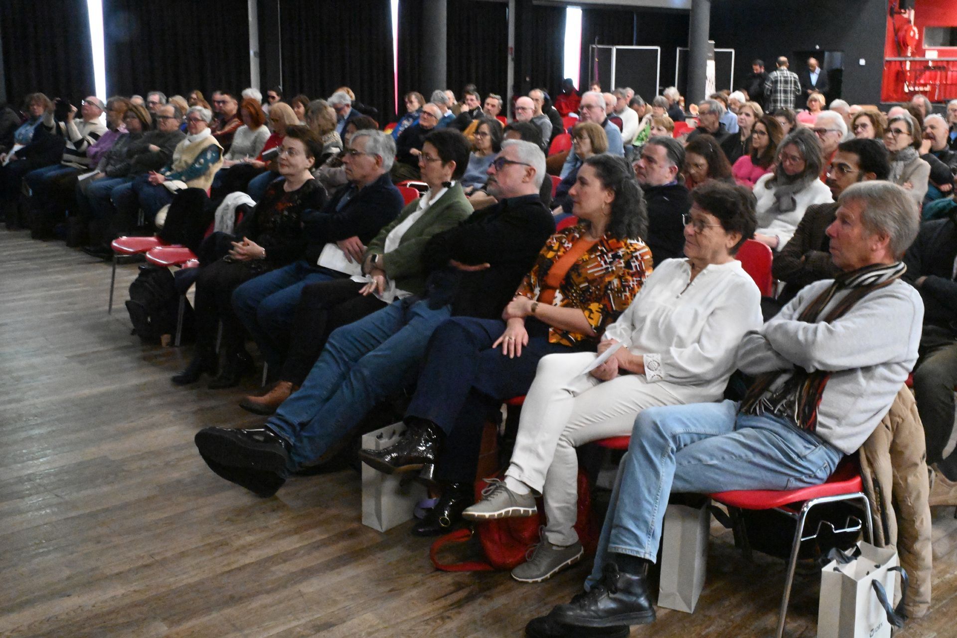 Public attentif, assis dans une salle et à l’écoute d’une présentation ou d’un événement
