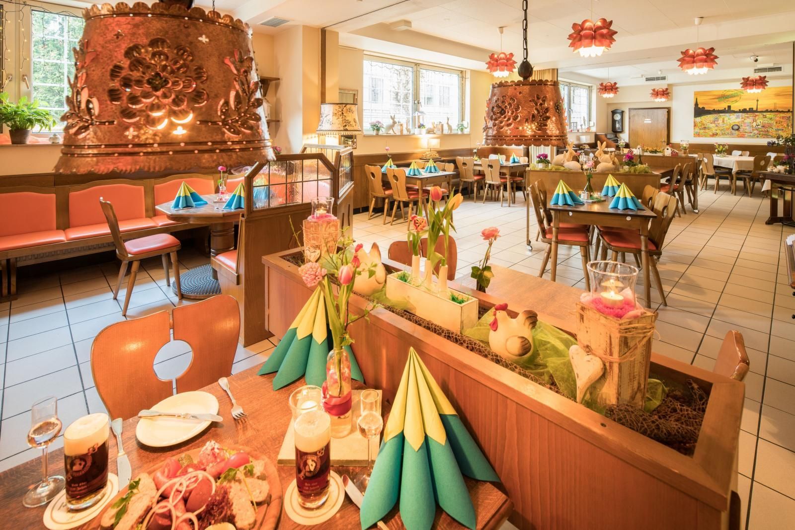 Festive restaurant dining room with decorated tables, colorful napkins, and warm ambient lighting