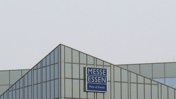 MESSE ESSEN sign on a modern glass building under a gray sky