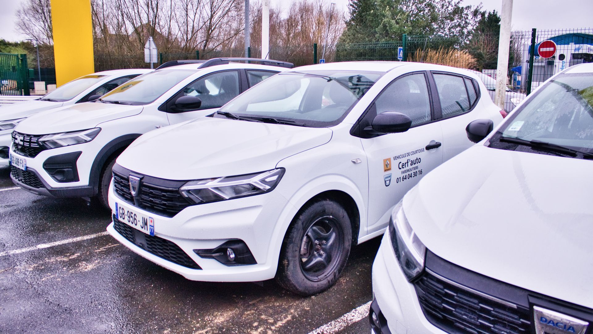 Plusieurs véhicules blancs Dacia garés