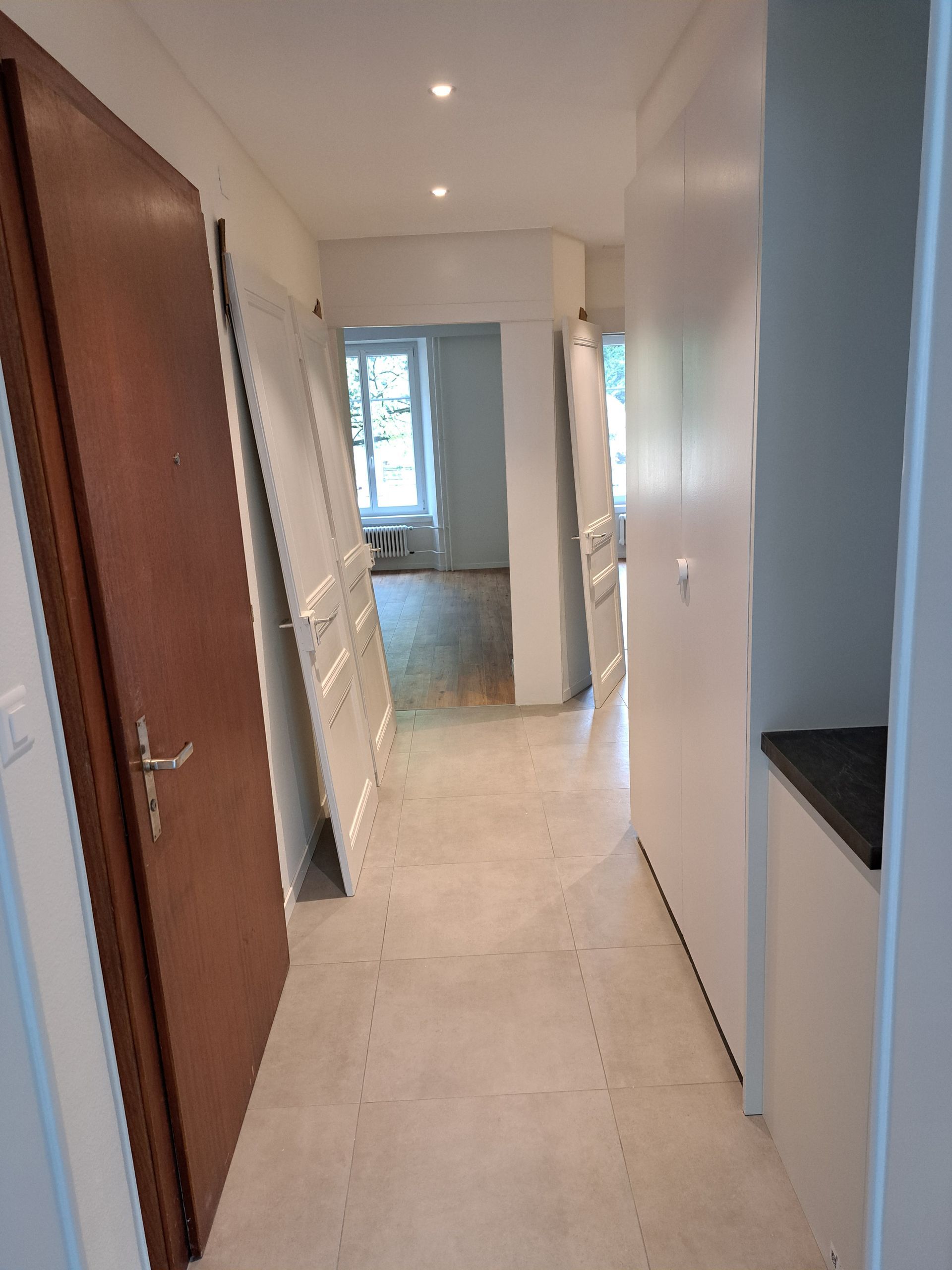 Illustration abstraite de montagnes stylisées et d'un soleil sur fond gris.