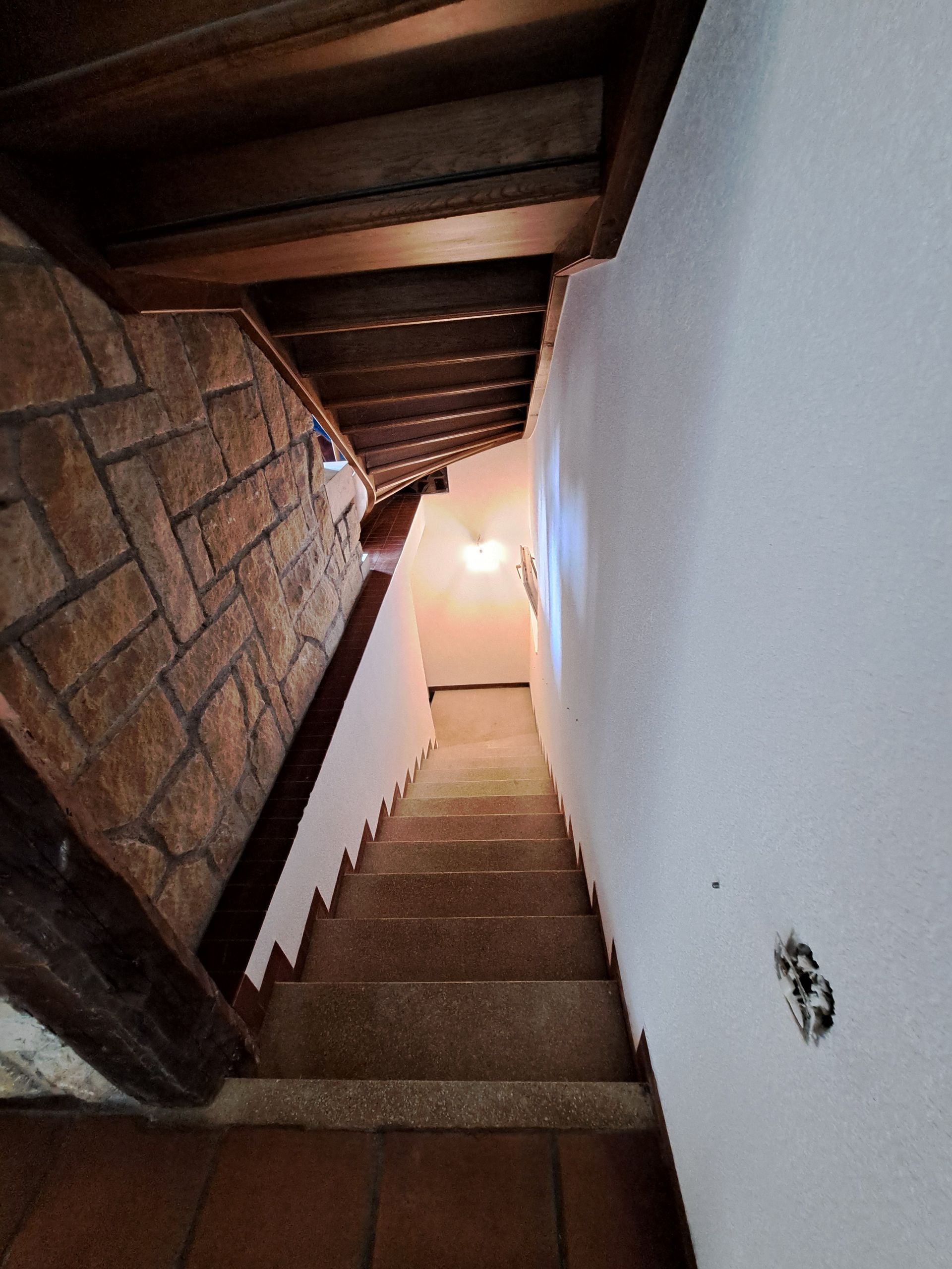 Illustration abstraite de montagnes stylisées et d'un soleil sur fond gris.