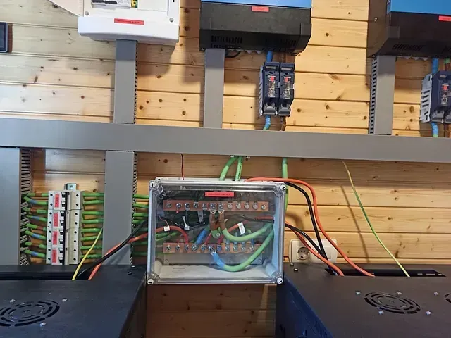 Un montón de equipos eléctricos están colgados en una pared de madera.