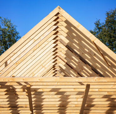 Le toit d'une maison en bois est en train d'être construit.