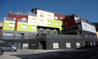 Un edificio grande con muchas ventanas y un coche aparcado delante.
