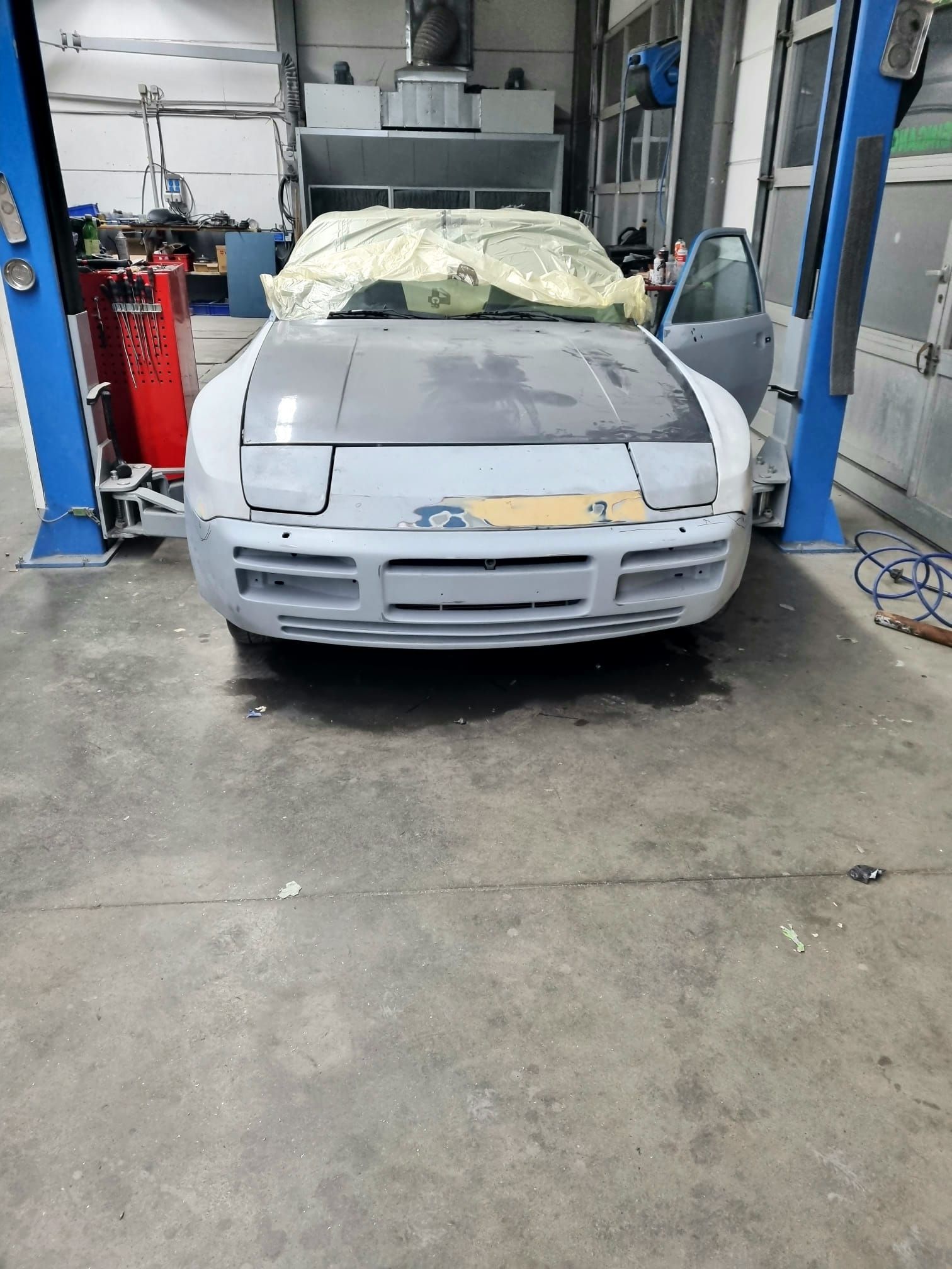 Ein Auto steht auf einer Hebebühne in einer Garage.