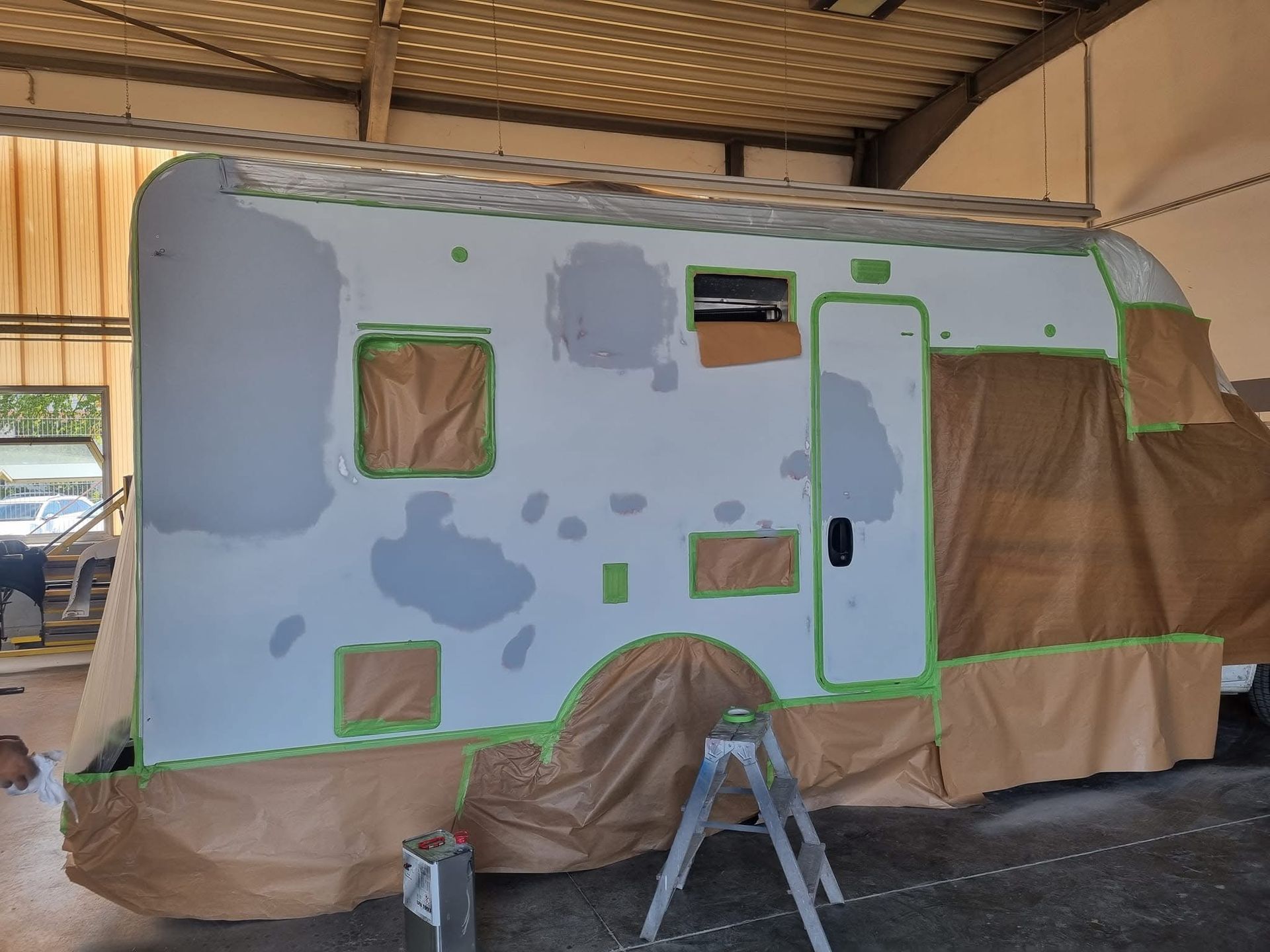 In einer Garage wird ein Wohnmobil lackiert.