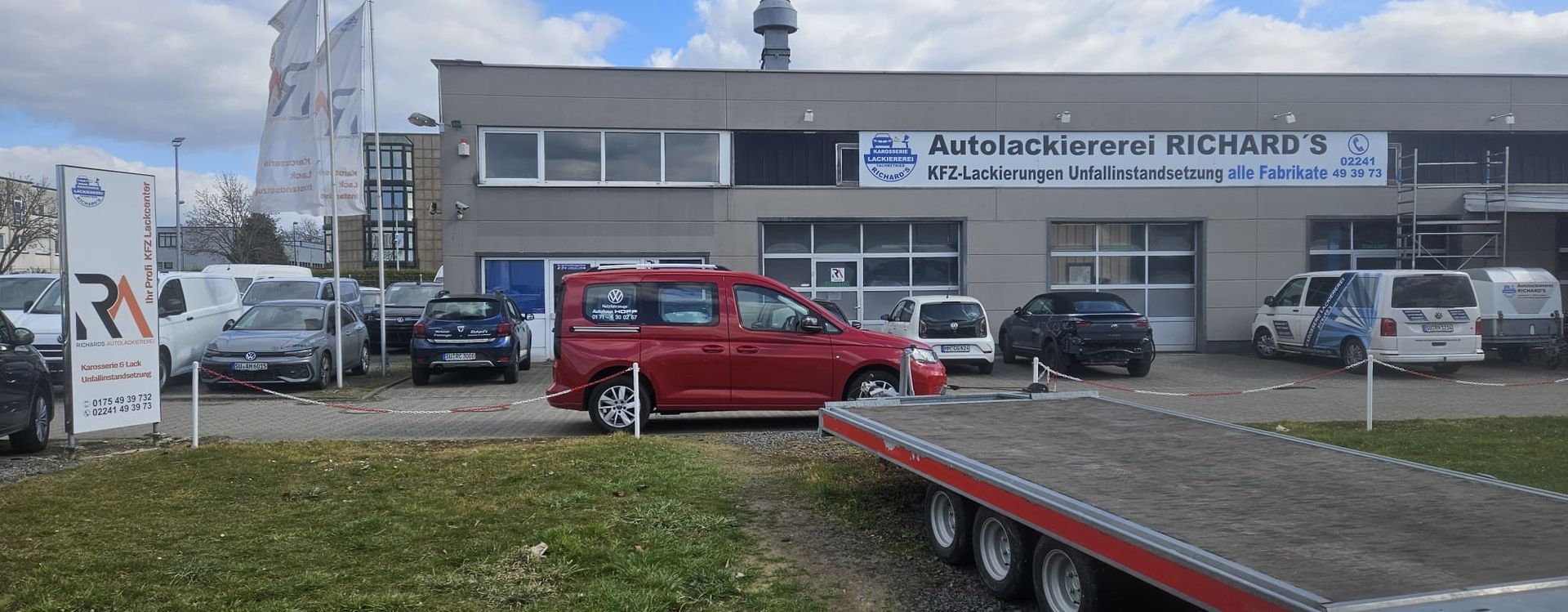 Ein roter Lieferwagen steht vor einem Gebäude.