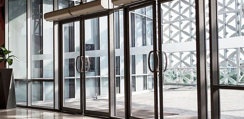 Un edificio con muchas ventanas y puertas corredizas de vidrio.