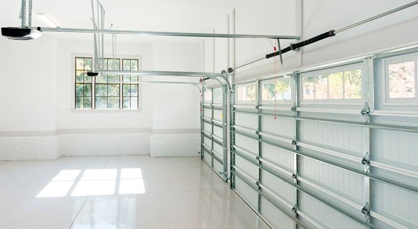 Un garaje vacío con una puerta de garaje abierta y una ventana.