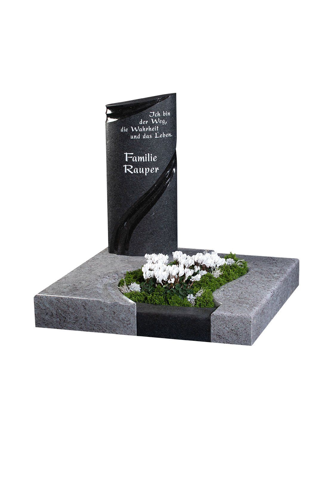 Grabstein mit schwarzem aufrecht stehenden Stein, grauem Sockel, weißen Blumen und grünem Moos.