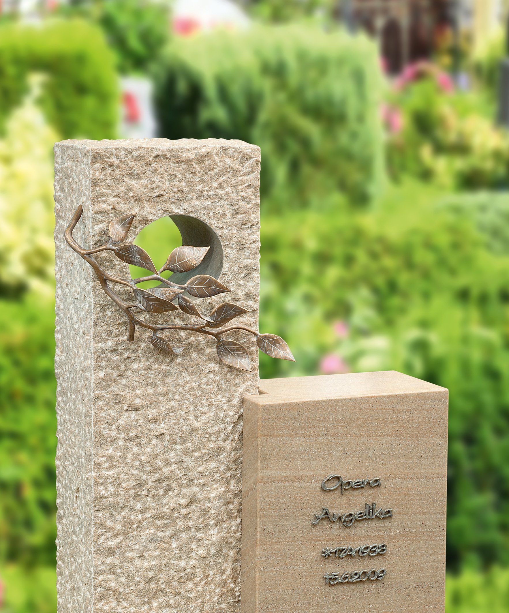 Denkmal auf einem Friedhof mit hoher Säule, Ausschnitt und Inschrift.