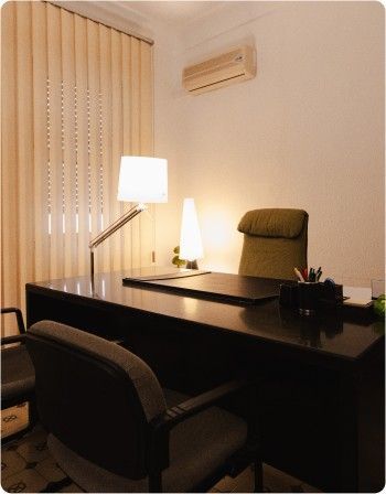 Escritorio de oficina moderno con lámpara, silla, persianas y aire acondicionado de pared