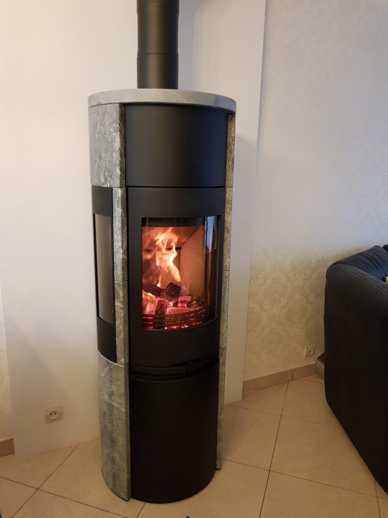 Poêle à bois noir devant un mur