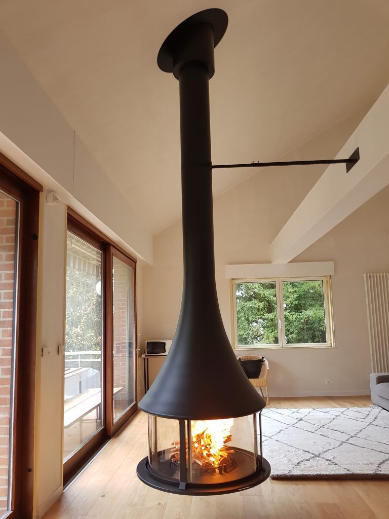 Cheminée ronde suspendue au milieu d'un salon vue de plus loin