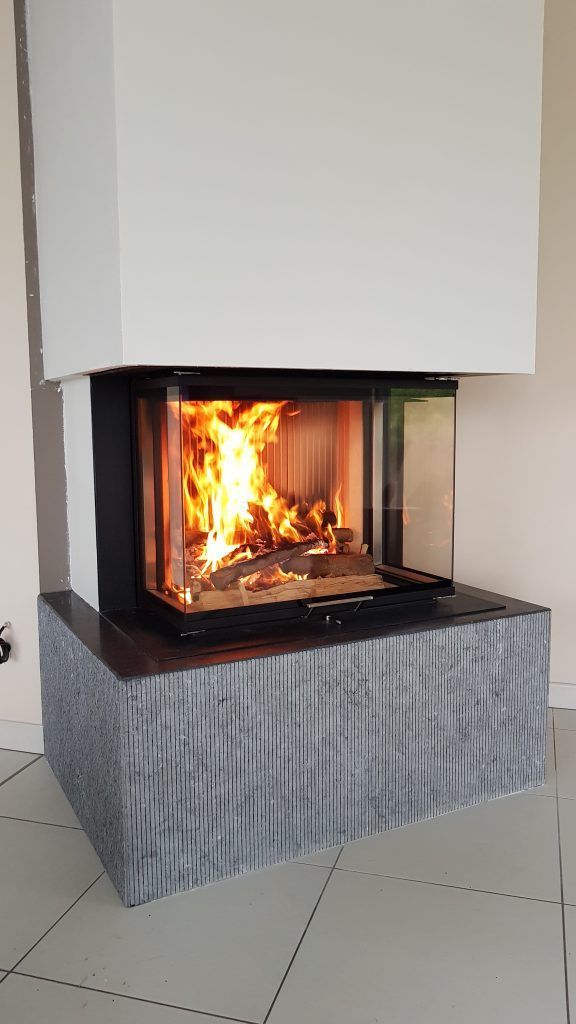 Zoom sur foyer bois d'un insert avec des vitres sur un support gris