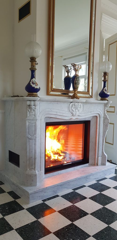 Belle cheminée d'époque réaménagée avec insert et carrelage en damier au solo