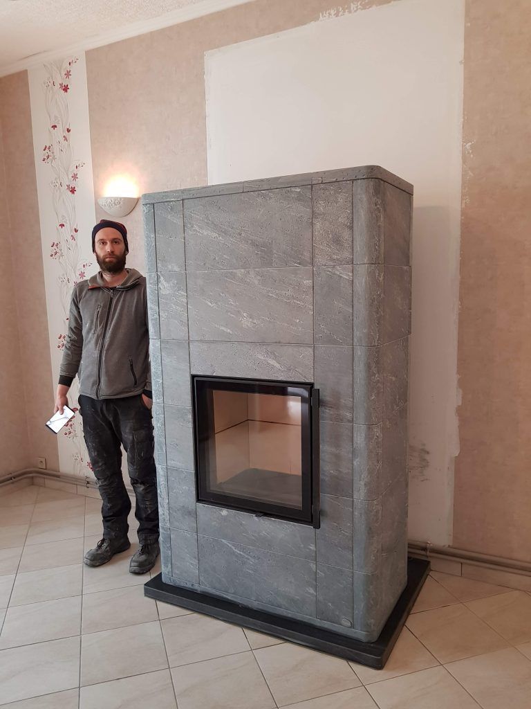 Réalisation 1 d'un poêle de masse Tulikivi avec un ouvrier de Reg'art Décors sur le côté