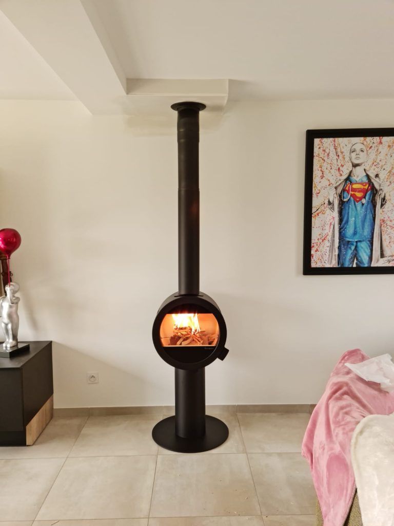 Poêle à bois de forme ronde devant mur blanc