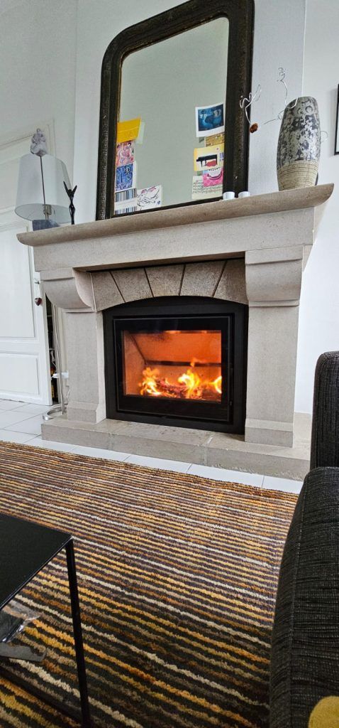 Vieille cheminée réaménagée avec un insert neuf au milieu de la cheminée