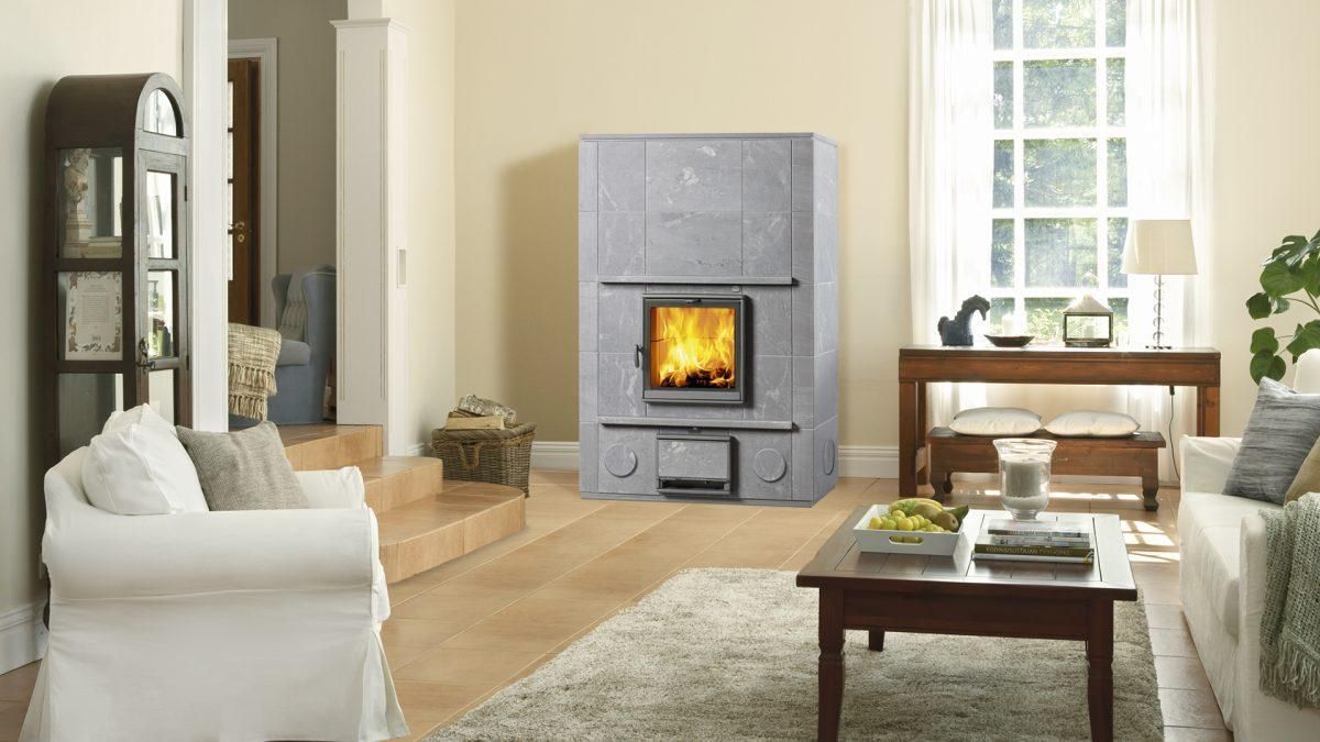 Poêle de masse finlandais au milieu d'un salon avec table basse et canapé