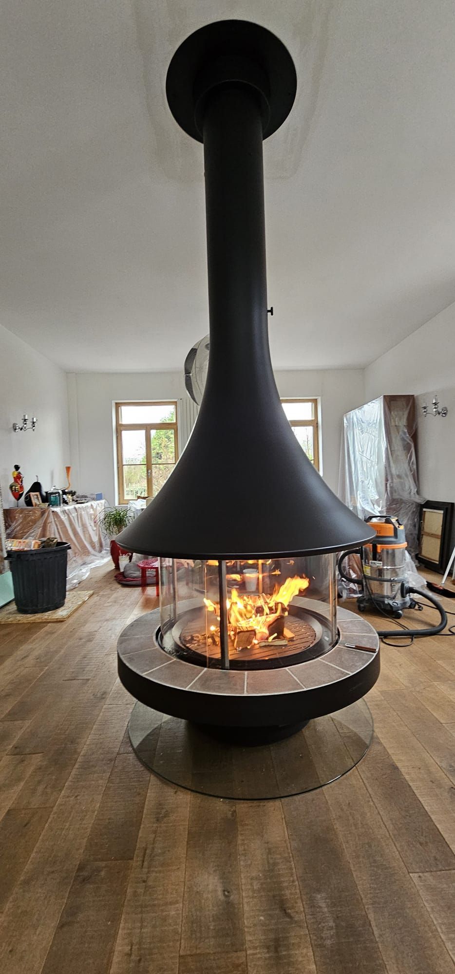 Cheminée design centrale et un feu flambant