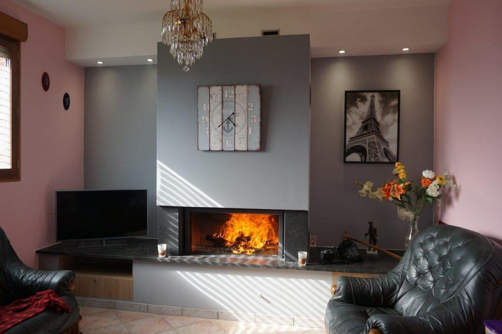 Insert bois au milieu d'un mur avec une télé à gauche et des murs roses et gris