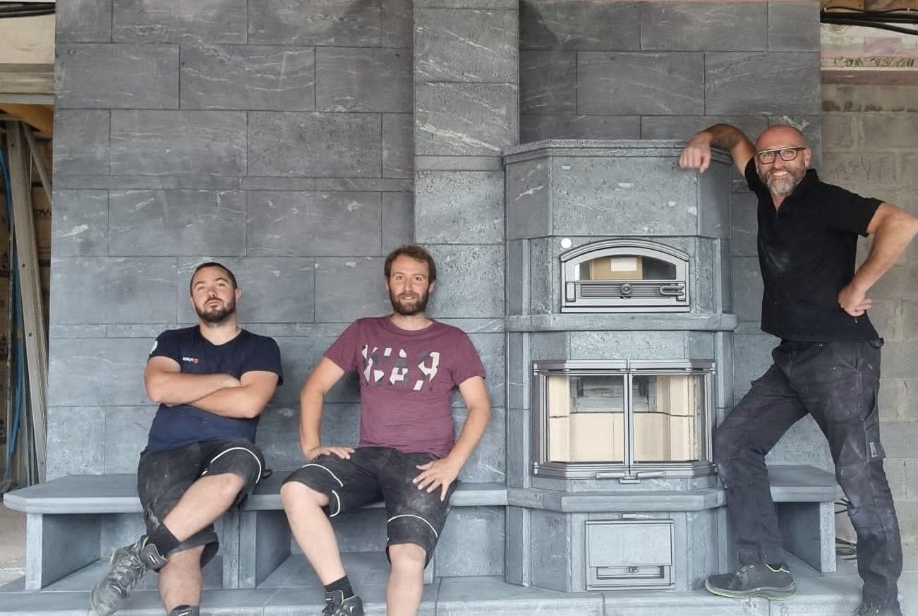 Employé de Reg'art Décors qui pose devant un poil Tulikivi qu'ils ont fini de moonter