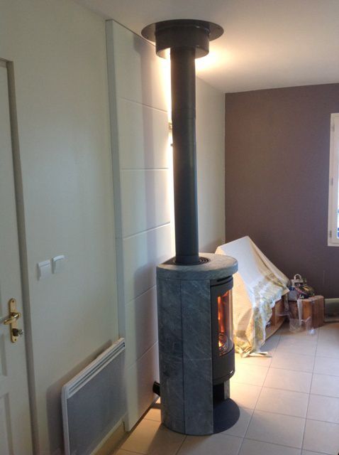 Poêle à bois de forme arrondi de couleur noir, vue de côté