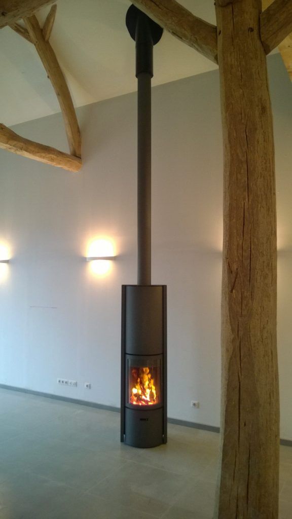 Poêle à bois de forme arrondi de couleur noir avec grande hauteur sous plafond