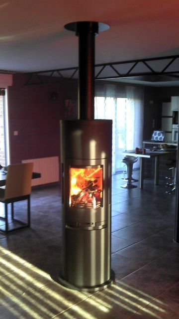 Poêle à bois de forme arrondi de couleur noir au milieu d'un salon