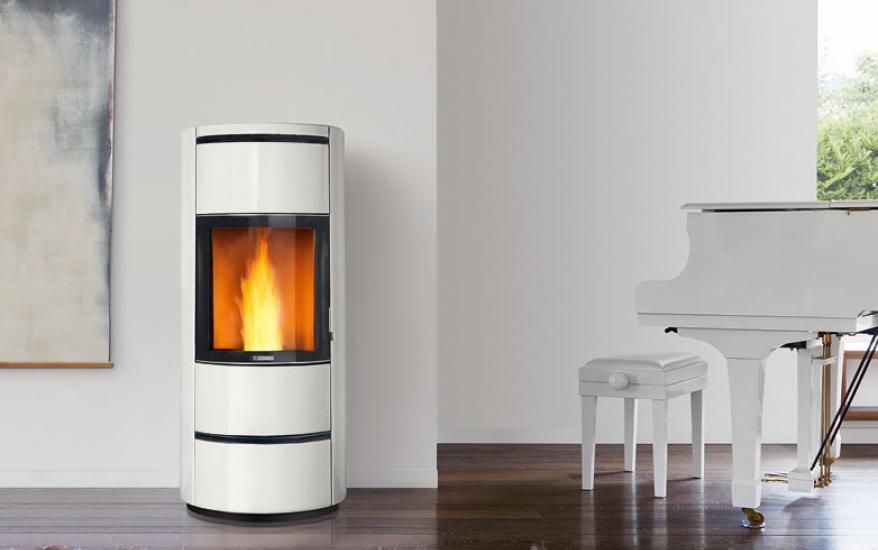 Poêle à granuler blanc avec mur blanc derrière et piano à droite
