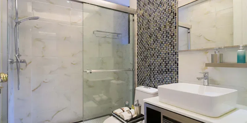 Un baño con lavabo, inodoro, ducha y espejo.