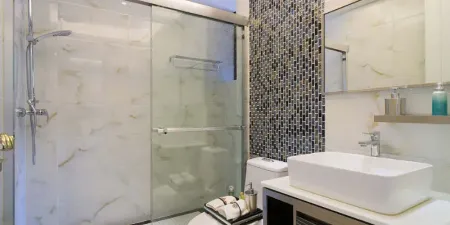 Un baño con lavabo, inodoro, ducha y espejo.