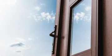 Un primer plano de una ventana abierta con un cielo azul de fondo.