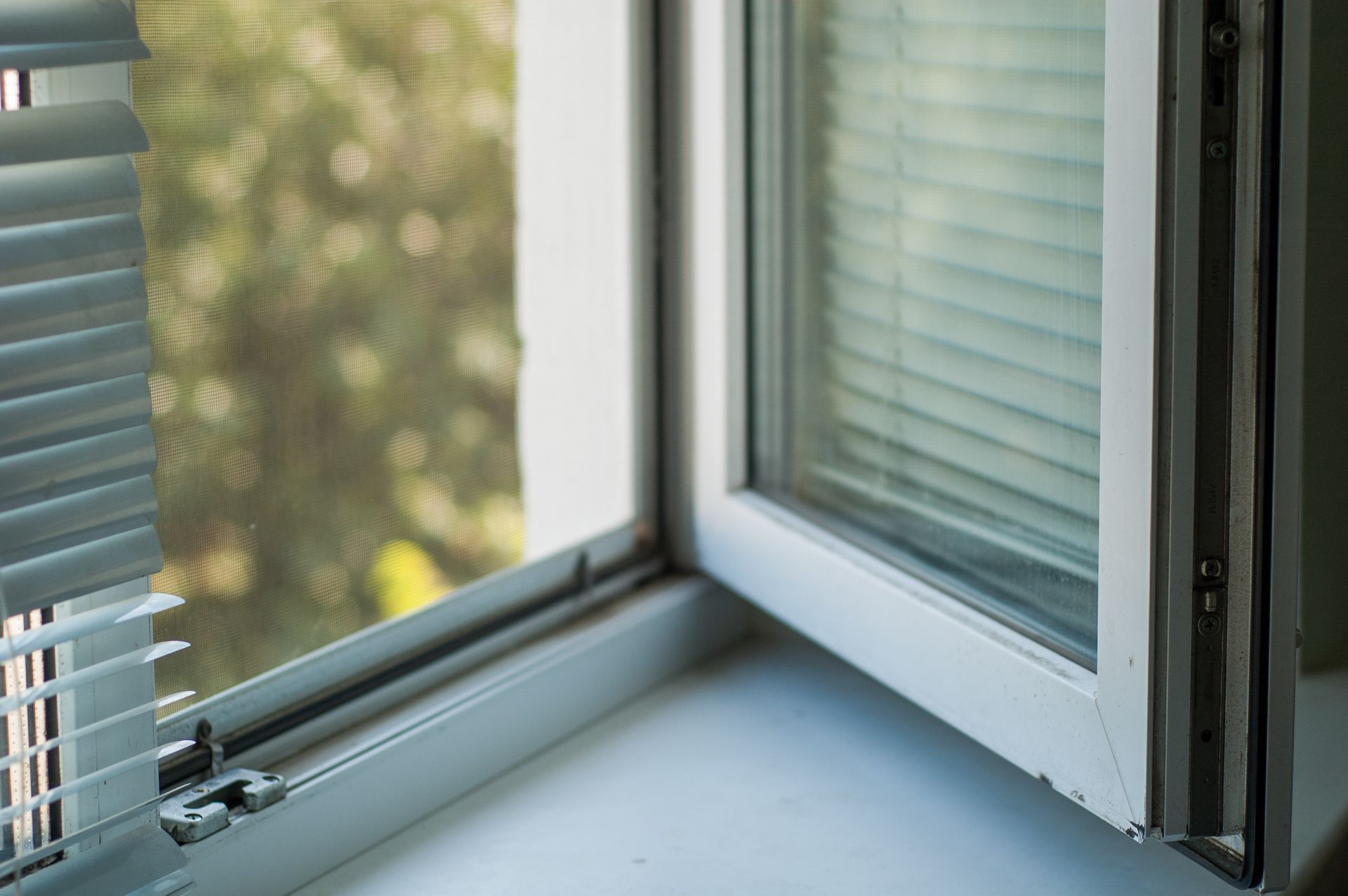 Un primer plano de una ventana abierta con persianas.