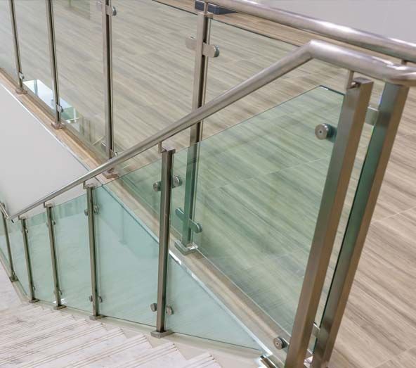 Una escalera con barandilla de cristal y barandilla de acero inoxidable.