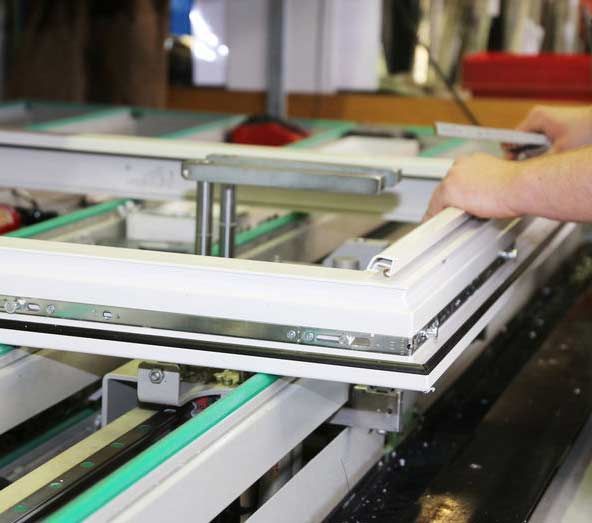 Una persona está trabajando en una máquina que está haciendo una ventana.
