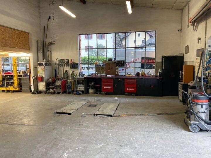 Interno di un'officina di riparazione auto con postazioni di lavoro e  attrezzi 