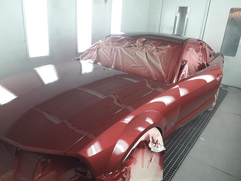 Peinture rouge dans l'atelier sur une voiture en rénovation