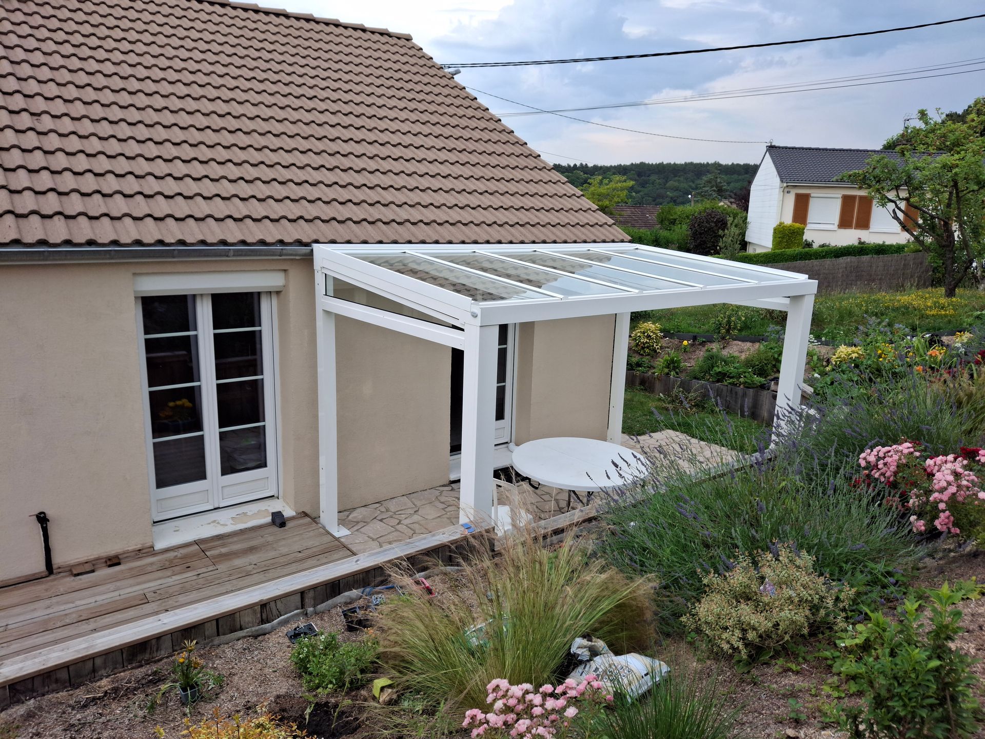 Patio de maison avec une pergola blanche et un jacuzzi rond dans un jardin