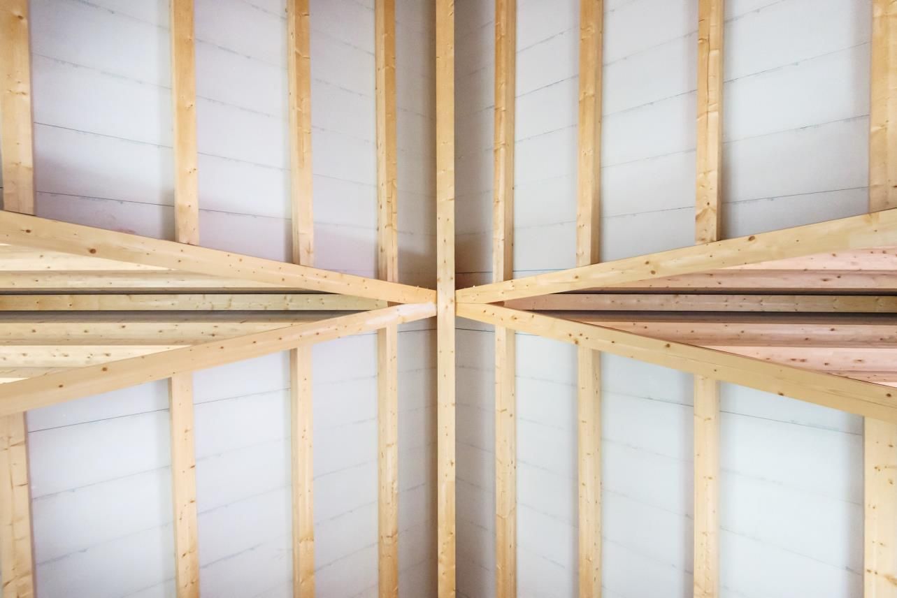 Se está construyendo el techo de un edificio con vigas de madera.