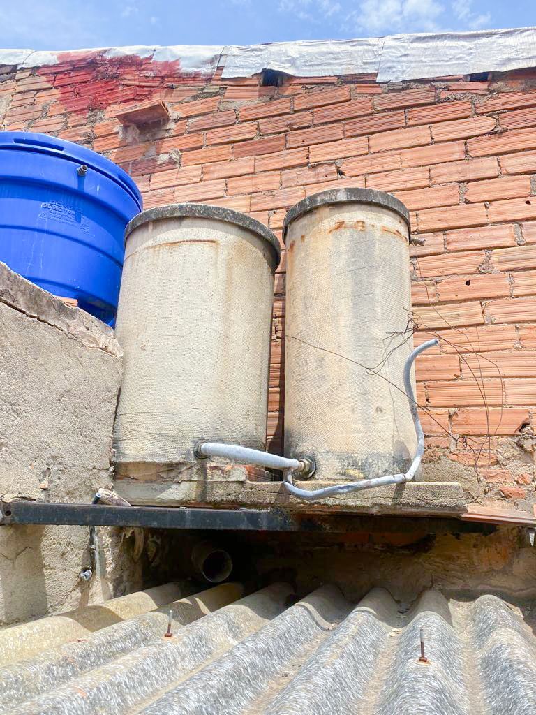 Dos hombres con monos blancos están trabajando en un tejado.