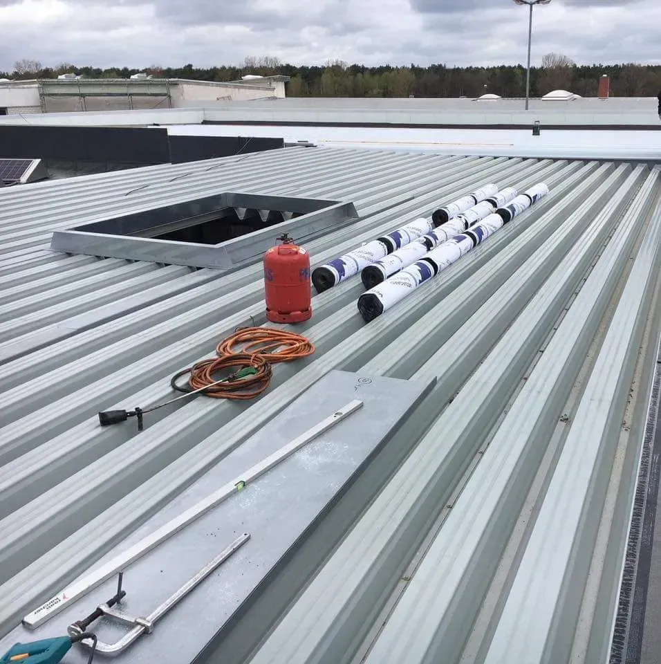 Ein Wellblechdach mit vielen Werkzeugen darauf.