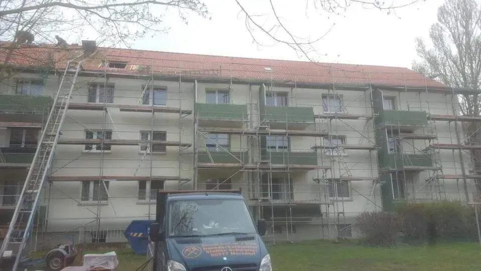 Arbeiten am Dach eines großen Mehrfamiliengebäudes einer Wohngesellschaft.