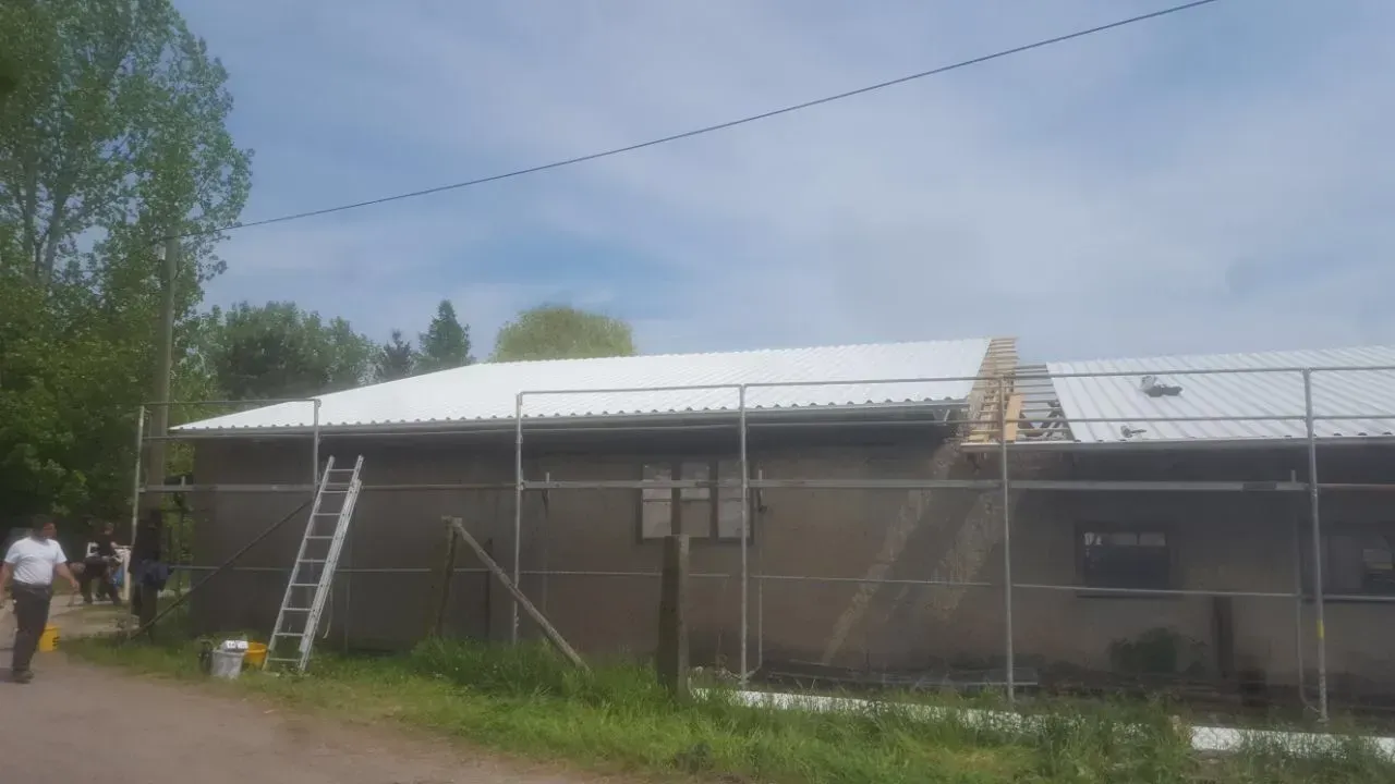 Dachdecker reinigen das Dach eines Gebäudes.
