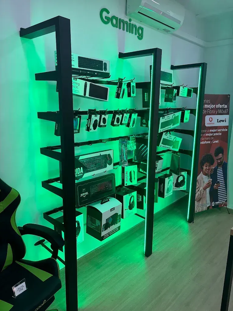 Estanterías de exposición iluminadas con luces verdes, con hardware informático en una tienda