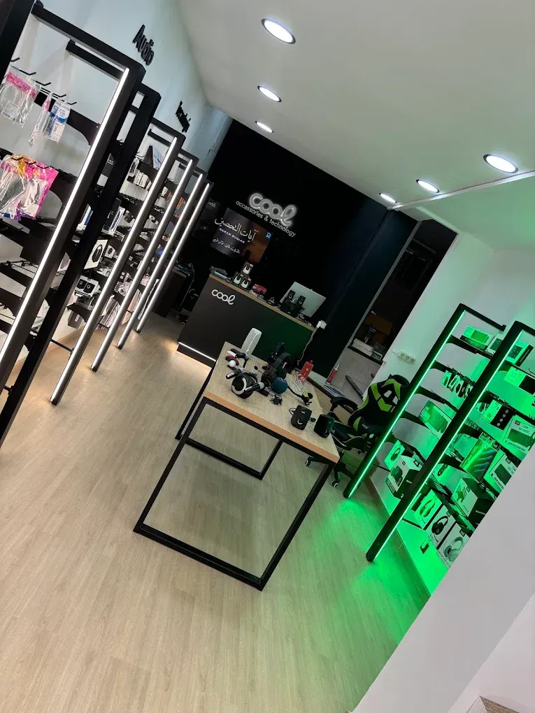 Interior moderno de una tienda minorista, con estanterías, mesas de exposición y expositores de productos iluminados en verde